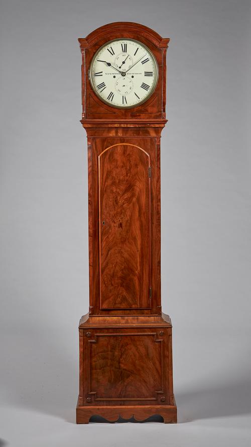 A late Regency mahogany longcase clockBy Newsome, TottenhamThe case with a shallow arch above a brass bezel and convex glass, flanked by canted angles