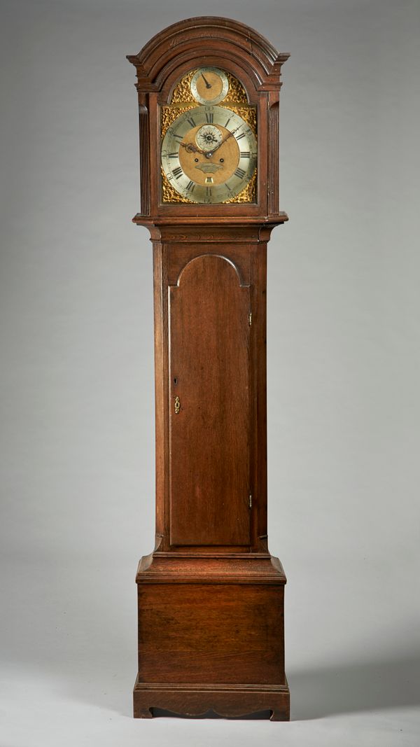 An oak longcase clockThe movement by Thomas Brass, Guildford, circa 1770The case with an arched pediment above glazed door and flanked by canted angle