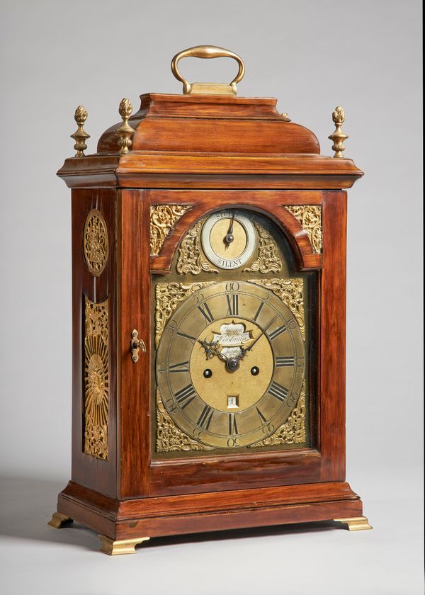 A giltmetal-mounted fruitwood bracket clockThe movement by Joseph Windmills, LondonThe bell-top case with a brass carrying handle and four flaming fin