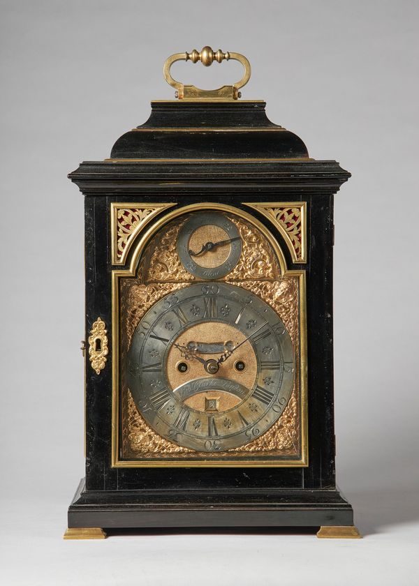 A giltmetal-mounted ebonised bracket clockInscribed George Clarke, LondonThe inverted bell-top case with a brass carrying handle, above a panel door w