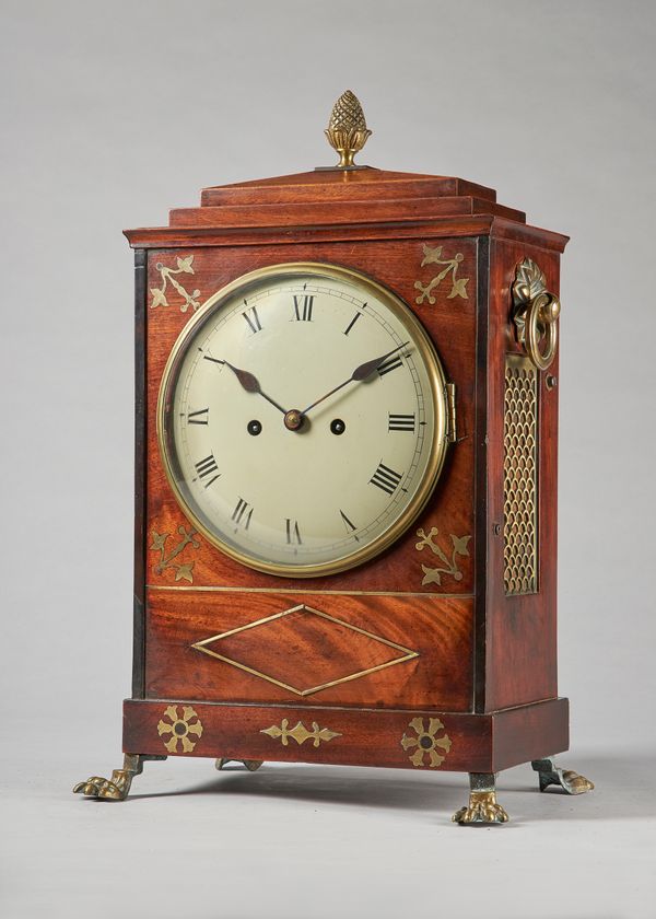 A Regency gilt brass-mounted mahogany and cut brass-inlaid bracket clockThe chamfer top with pineapple finial above a stepped pediment, the brass glaz