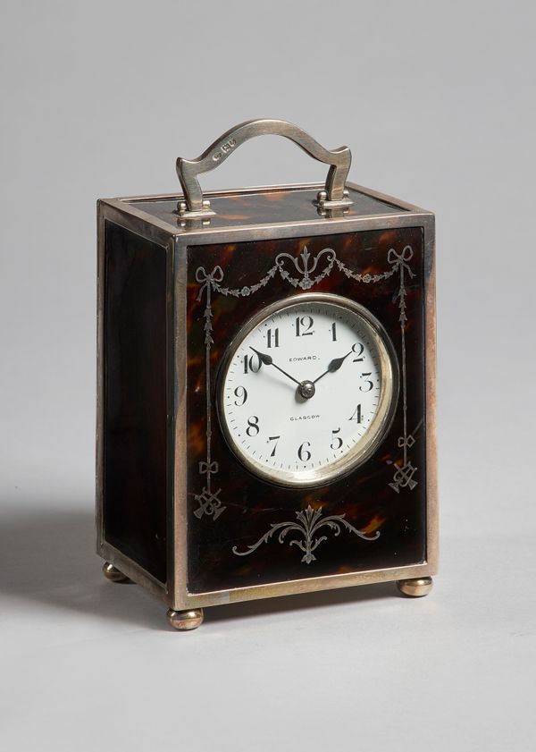 An Edwardian silver and tortoiseshell carriage clockLondon 1909The rectangular case with a shaped handle above ribbon-tied foliate decoration to the f