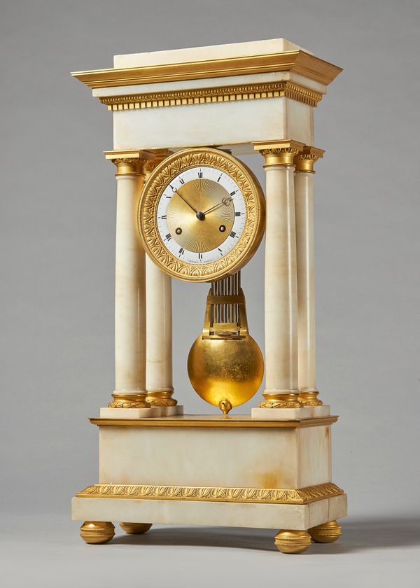 An Empire ormolu and white marble portico clockBy Gérard, ParisThe case with a stepped pediment  above egg-and-dart and dentil moulding, with four tur