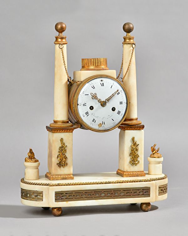 A FRENCH GILTMETAL-MOUNTED MARBLE MANTEL CLOCK  Early 19th century and later    Modelled with a drum-shaped case, supported between a pair of tapered