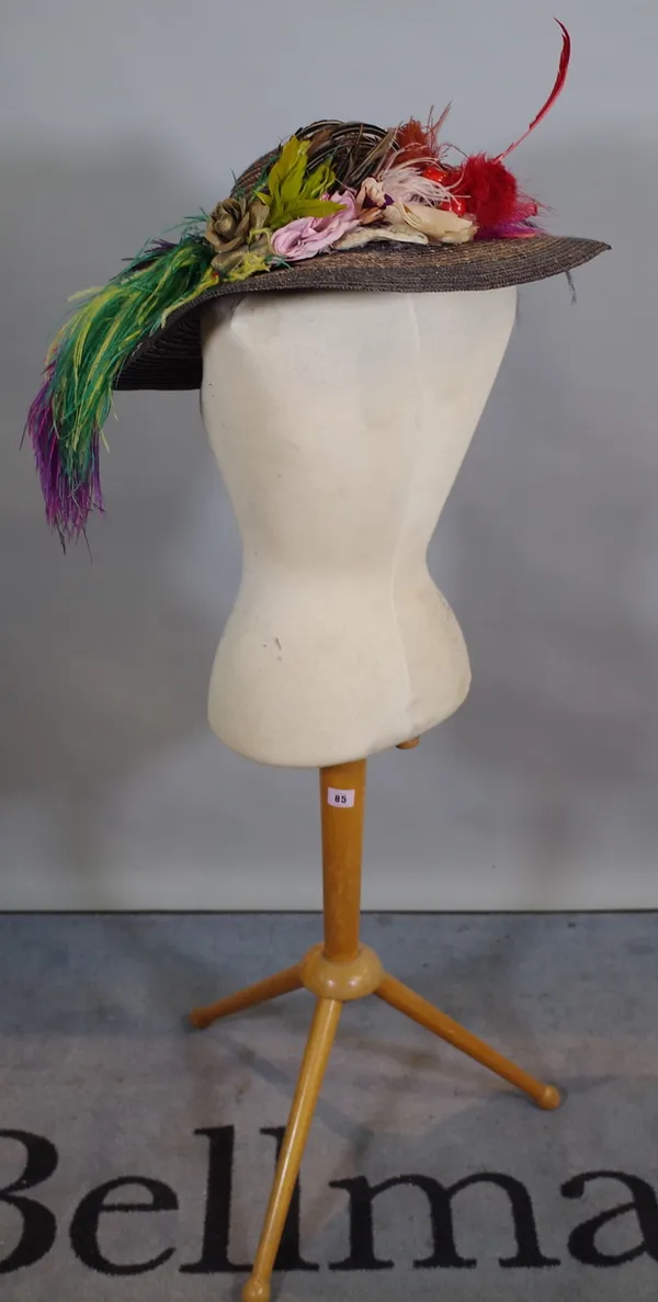 A 20th century tailor's dummy on beech tripod base, together with a colourful ladies hat.