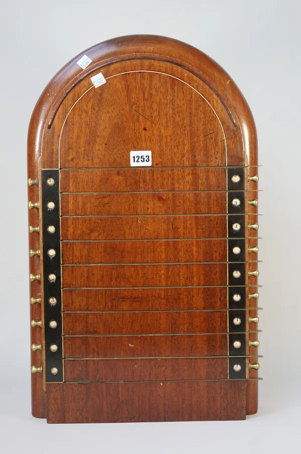 An early 20th century mahogany 'Shove ha'penny' board with brass raised markers and a revolving score system, 59cm high.