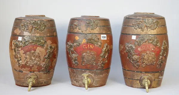 A set of three terracotta spirit barrels, late 19th century, 'Brandy, Whisky and Gin', each relief moulded with fruiting vines and gilt titled against