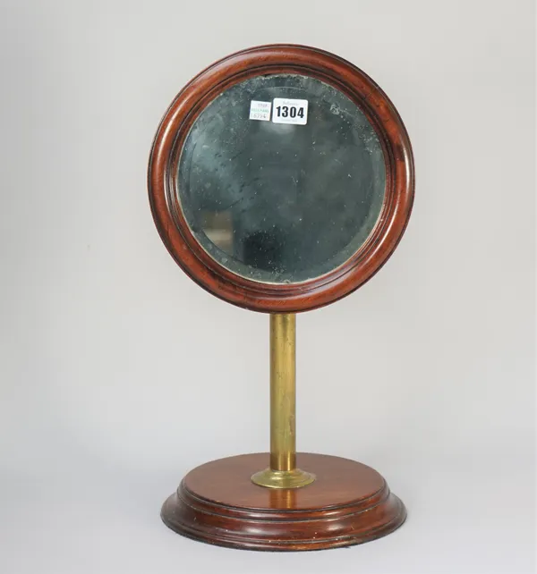 An early 20th century mahogany and brass dressing table mirror with adjustable circular frame and stepped circular base, 46cm high.