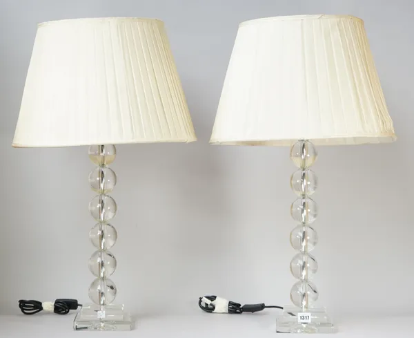 A pair of modern clear perspex table lamps of spherical sectional form over a stepped square base with cream pleated shades, 50cm high, (2).