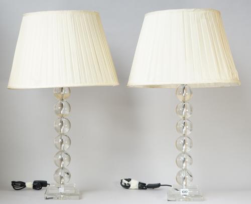 A pair of modern clear perspex table lamps of spherical sectional form over a stepped square base with cream pleated shades, 50cm high, (2).