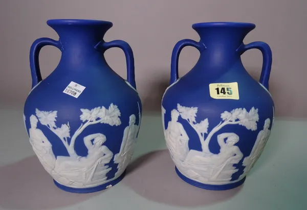 A pair of Wedgwood blue Jasper Ware twin handled vases, decorated with classical figures, 24cm tall.