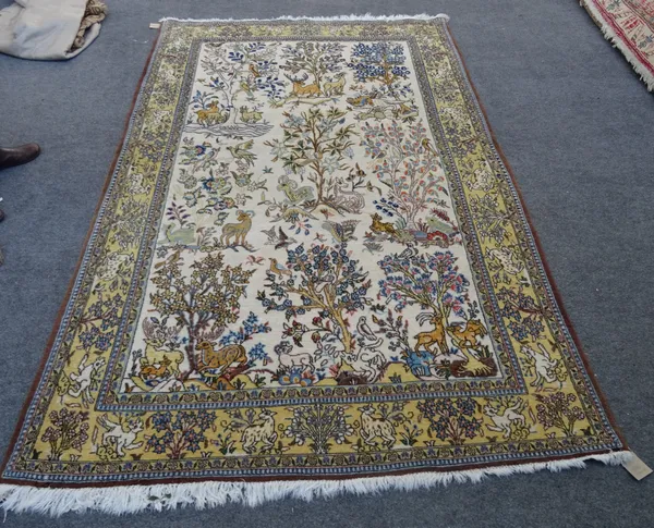 A part silk Qum rug, Persian, the ivory field with single flowering trees, each with animals and birds and a saffron matching border, 248cm x 154cm.