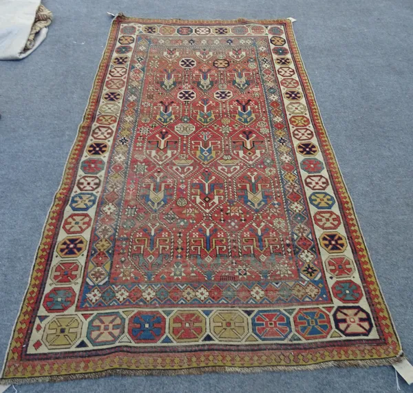 A Gendje rug, Caucasian, the madder field with a trellis with each section bearing a stylised flowerhead, an ivory flowerhead medallion border, 224cm