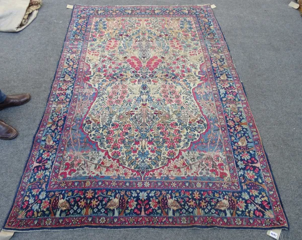 Kerman 'Tree of Life' prayer rug, Persian, the ivory mehrab field with abundantly floral trees and sprays, pairs of birds and indigo floral arch above