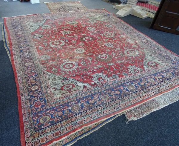 A Fereghan carpet, Persian, the madder field with all over angular floral vines and palmettes, ivory spandrels, an indigo palmette and vine border, 31