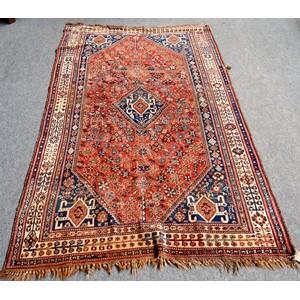 A Ghashgai carpet, South Persian, the floral madder field with a hooked central medallion, four matching spandrels, an ivory plant border, 283cm x 170