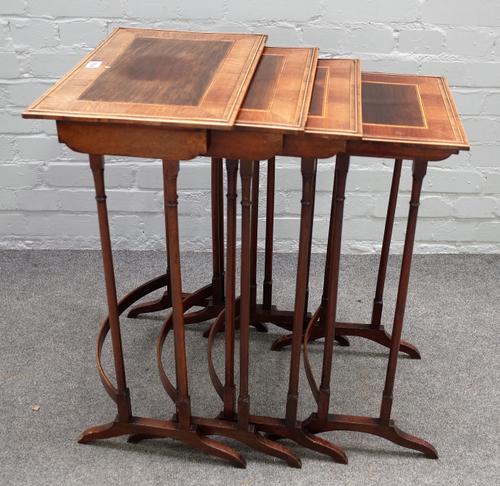 A nest of four George III mahogany quartetto tables, with rosewood banding, box and ebony stringing, on ring turned supports, 31cm wide x 47cm high.