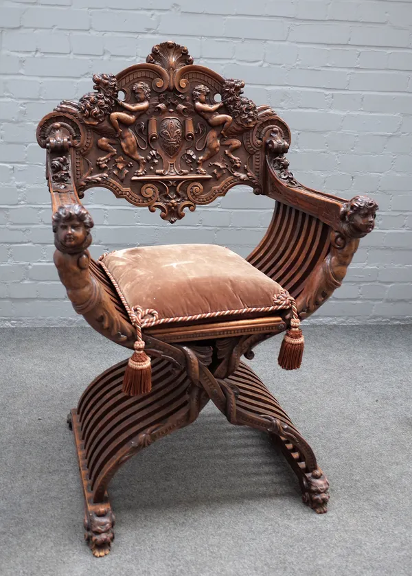 A 19th century Italian carved walnut Savonarola chair, with figural supports, 70cm wide x 109cm high.