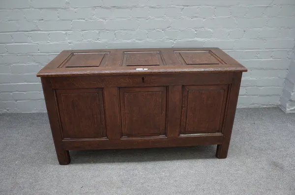 A 17th century oak coffer with triple panel lid and front, on stile feet, 105cm wide x 55cm high.