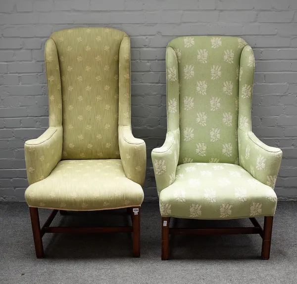 A pair of 18th century style high wingback armchairs, on stained beech block supports, 70cm wide x 128cm high, (2).