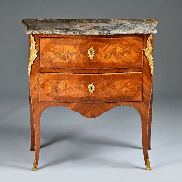 A Louis XV walnut petit commode, the grey marble top over serpentine bombe gilt metal mounted floral marquetry two drawer base, 75cm wide x 82cm high.