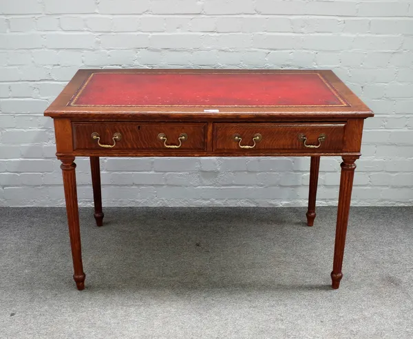 Warings; an oak two drawer writing desk on tapering fluted supports, 115cm wide x 76cm high.