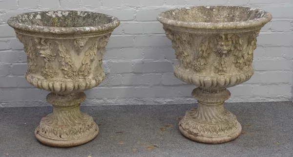 A pair of reconstituted stone jardinieres, with Green Man and swag moulded bodies, on spiral fluted pedestals, 55cm diameter x 62cm high.