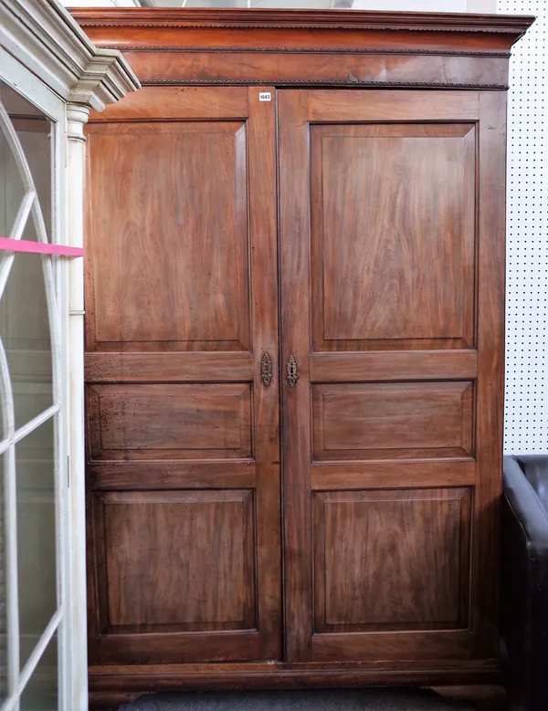 A George III mahogany breakdown wardrobe with a pair of triple panel doors, on bracket feet, 142 cm wide x 206 cm high.