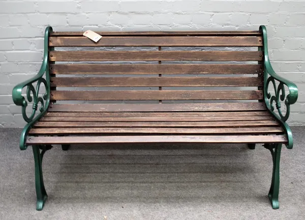 A 20th century green painted cast iron garden bench with scroll ends and wooden slats, 128cm wide x 78cm high.