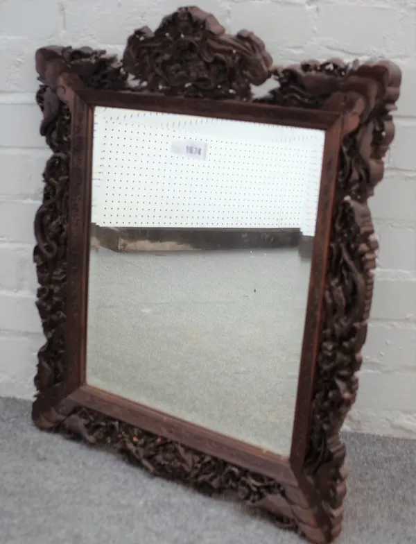 A Chinese hardwood mirror with extensively carved frame depicting hunting scenes, dragons and wildlife, 50cm wide x 64cm high.