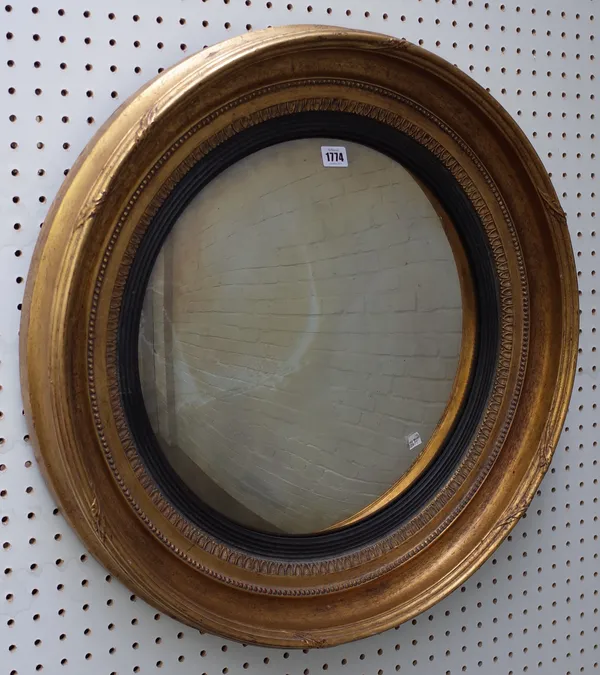 A 19th century gilt framed circular convex wall mirror with moulded frame and ebonised slip, 67cm diameter.