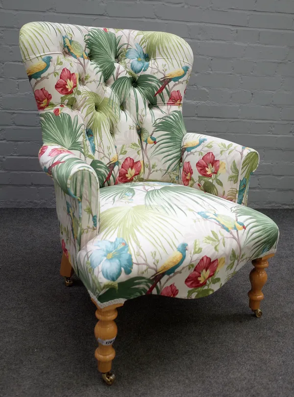 A Victorian style easy armchair with button upholstered spoon back and serpentine seat on turned supports, 61cm wide x 90cm high.