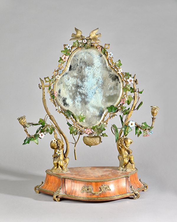 A 19th century French toilet mirror, the bevelled plate mounted with trailing glass and enamel flowers on ormolu candelabra supports, resting on a cub