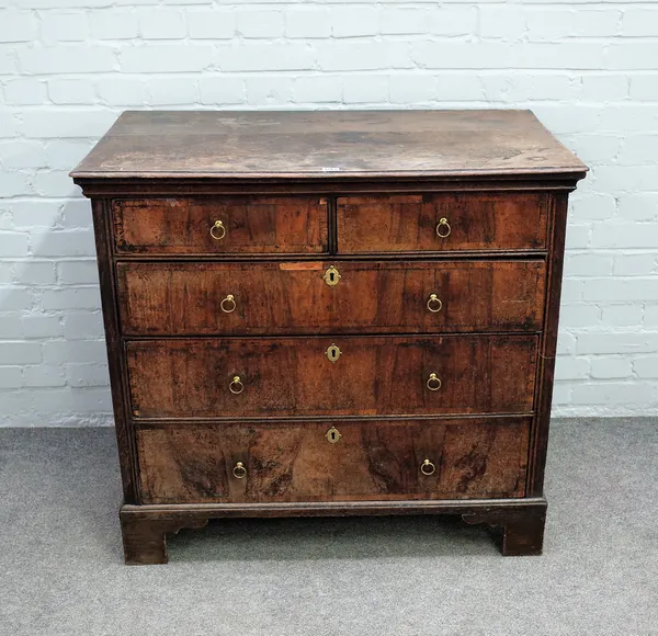 An early 18th century oak and walnut chest with two short and three long graduated drawers on bracket feet, 98cm wide x 91cm high.