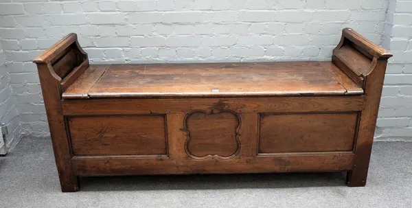 A 17th century oak box settle with pair of raised candle box ends over plank lift top and triple panel front, 180cm wide x 81cm high.