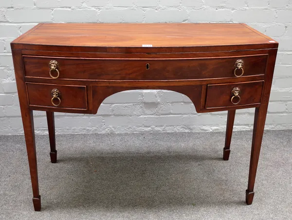 A George III mahogany bowfront writing desk with three frieze drawers on tapering square supports, 92cm wide x 71cm high.