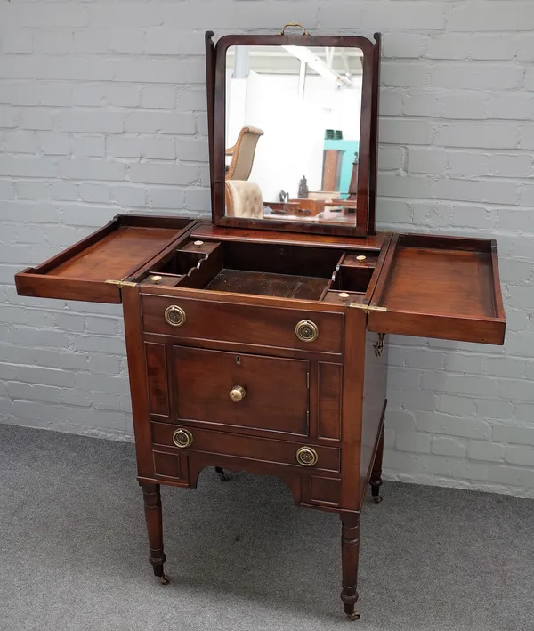 A George III mahogany gentlemans washstand, with lift top over cupboards and drawer on turned supports, 59cm wide x 97cm high.