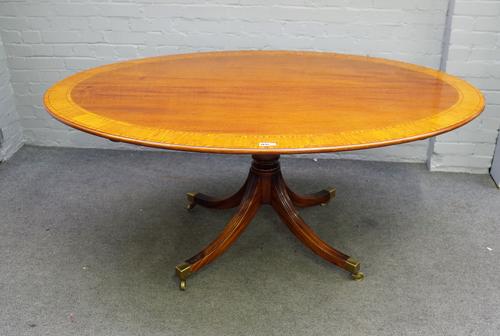 Possibly William Tillman; a George III style satinwood banded mahogany breakfast table, the oval snap top on four downswept supports, 120cm x 170cm.