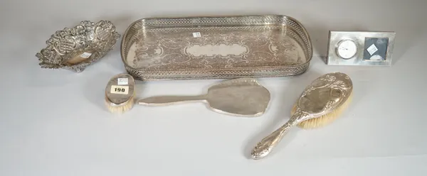 A silver plated tray, two silver mounted brushes, a silver mounted mirror, silver mounted clock and bon bon dish, (6).