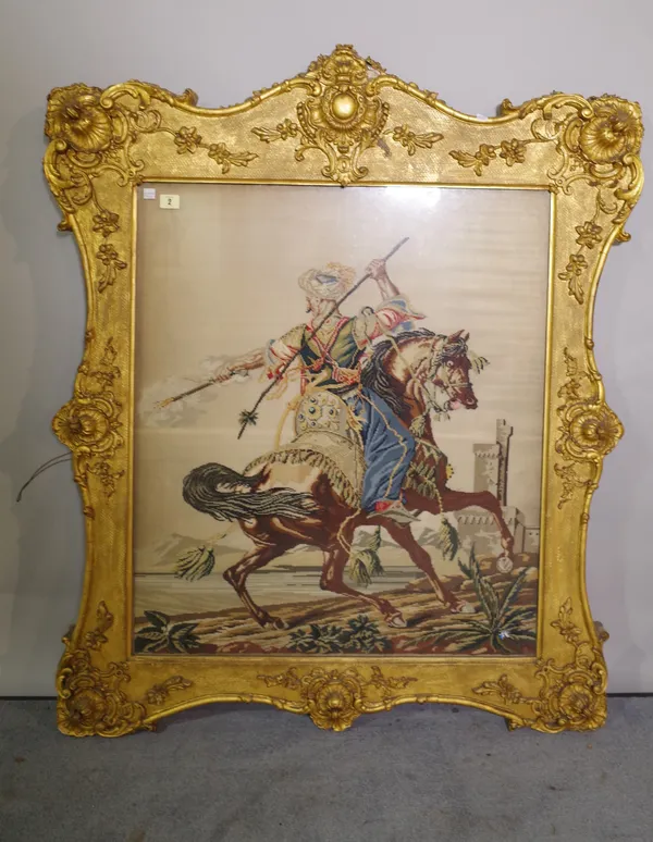 A 19th century needlework tapestry, depicting a Persian figure on horseback, in a shaped gilt frame, 100cm wide x 105cm tall.