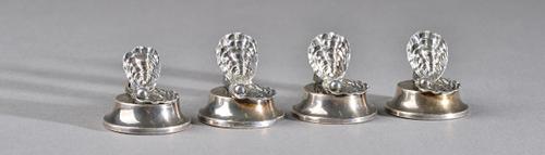 A set of four silver place name or menu stands, each formed as an open seashell, exposing a bead representing a pearl, on a loaded circular base, Birm