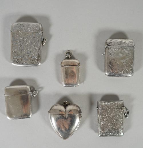 A Victorian silver heart shaped plain vesta case, Birmingham probably 1895, three rectangular vesta cases, having engraved decoration, a small rectang