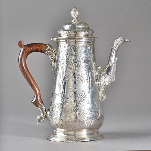 A George II silver coffee pot, of tapered cylindrical form, with later floral, foliate and scroll embossed decoration, the hinged cover with a bud fin
