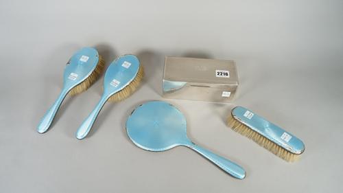 A lady's silver and pale blue enamelled four piece part dressing set, comprising; a hand mirror, two hairbrushes and one clothes brush, Birmingham 192