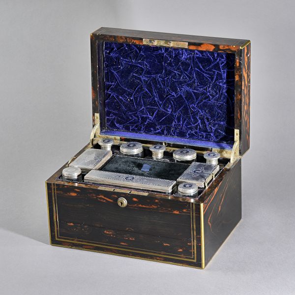 A Victorian corromandel wood travelling rectangular lady's toilet box, the interior with ten silver lidded glass toilet bottles, boxes and jars, the m