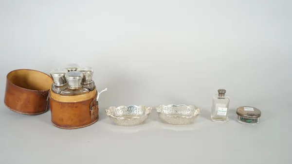 A set of four silver topped glass lotion bottles, with a leather case, Birmingham 1905, a faceted glass scent bottle, a circular toilet box and a pair