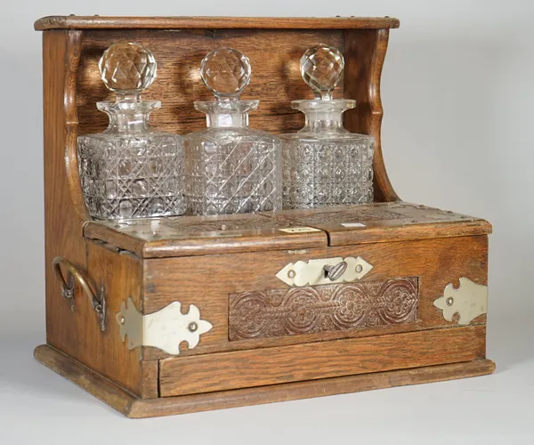 An early 20th century oak cased three division tantalus, 35cm wide x 32cm high.