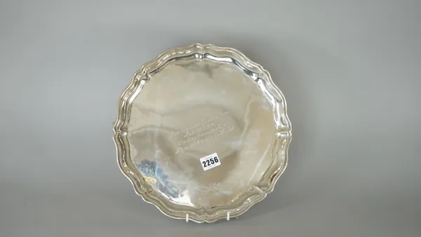 A foreign salver of shaped circular form, presentation inscribed, raised on three scrolling feet, detailed Silver, diameter 31cm, weight 844 gms.