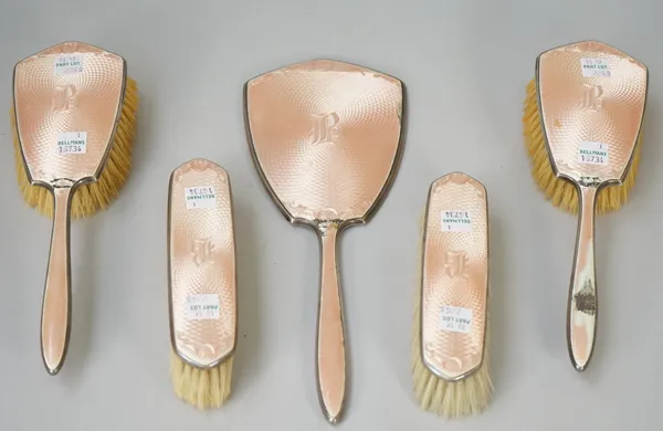 A lady's silver and pink enamel mounted five piece part dressing set, comprising; a hand mirror, two hairbrushes and two clothes brushes, each detaile
