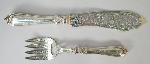 A pair of Victorian silver fish servers, each with pierced and engraved decoration and with loaded silver handles, Birmingham 1851, gross combined wei